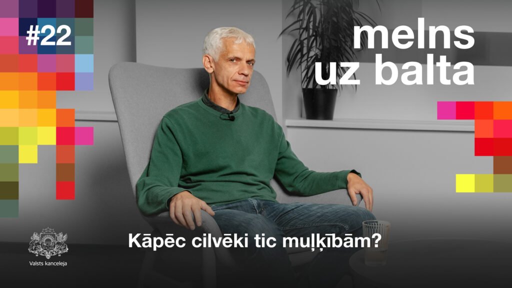 Ivars Austers sēž uz krešla, skatās kamerā.